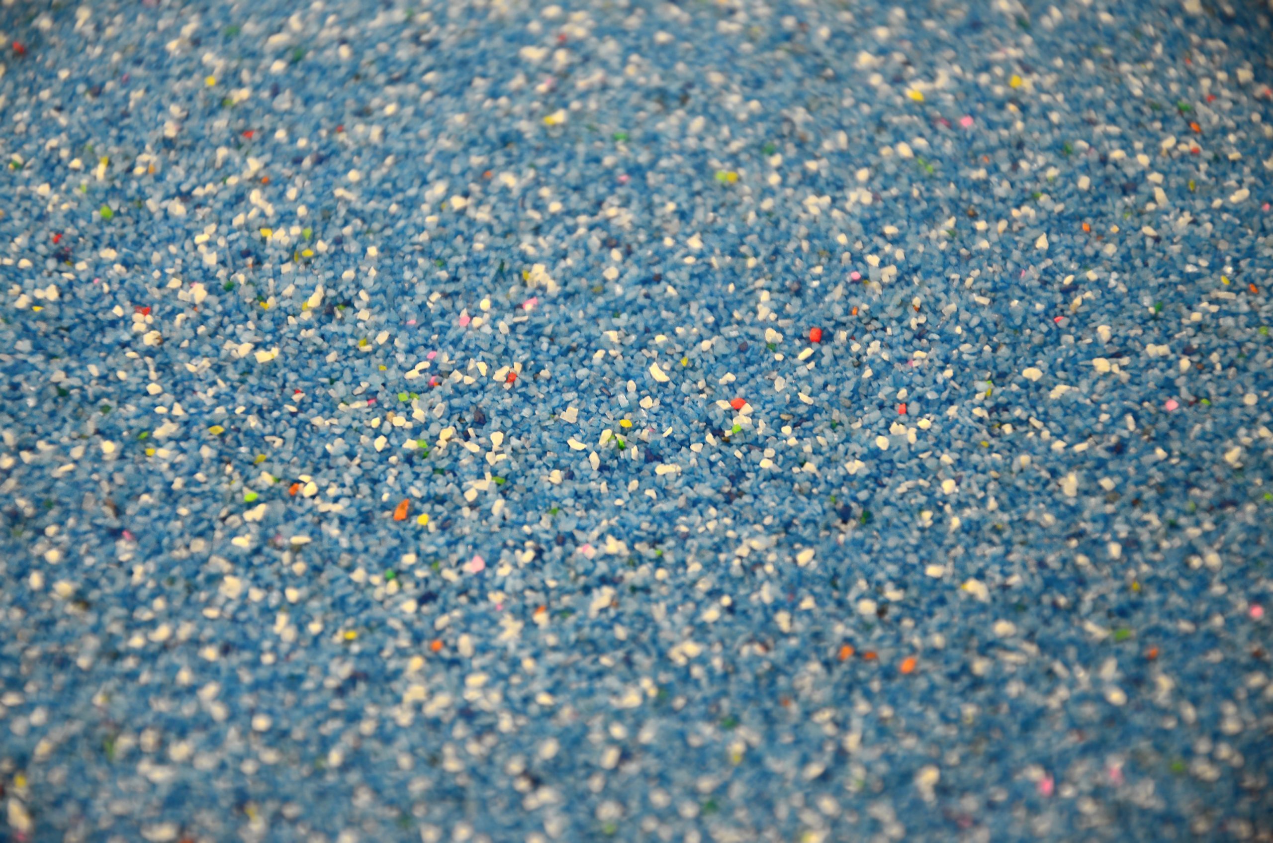 Texture of a colored granular sand close up. Blue grains